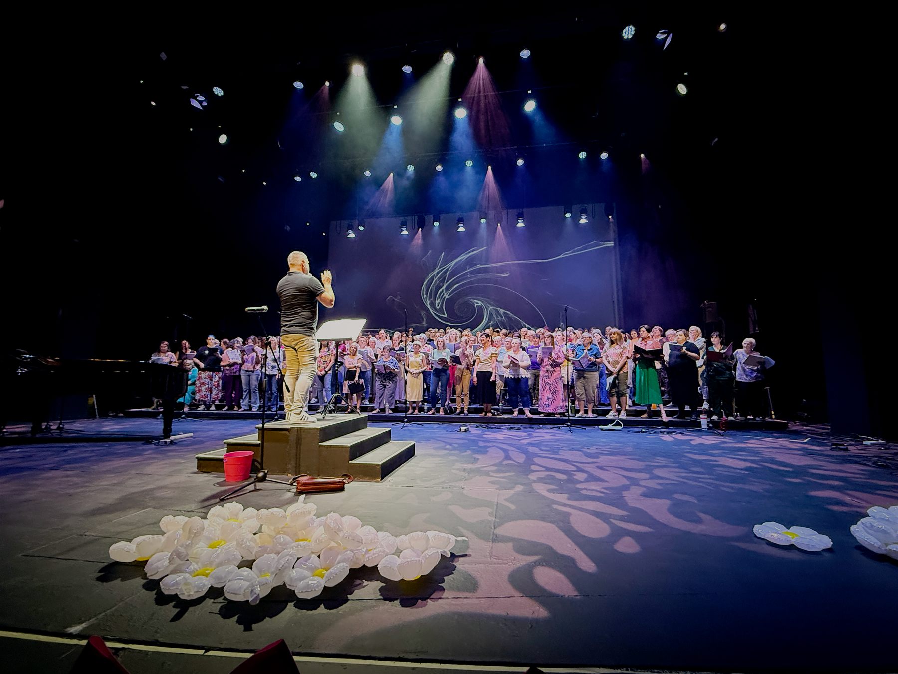 Sing Sussa Sing — Christo Burger theatre production with pink-wash stage and floral set dressing